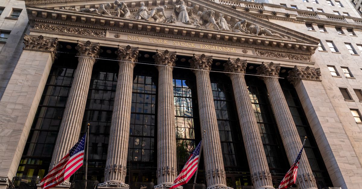 La facciata neoclassica del New York Stock Exchange con le bandiere americane che sventolano