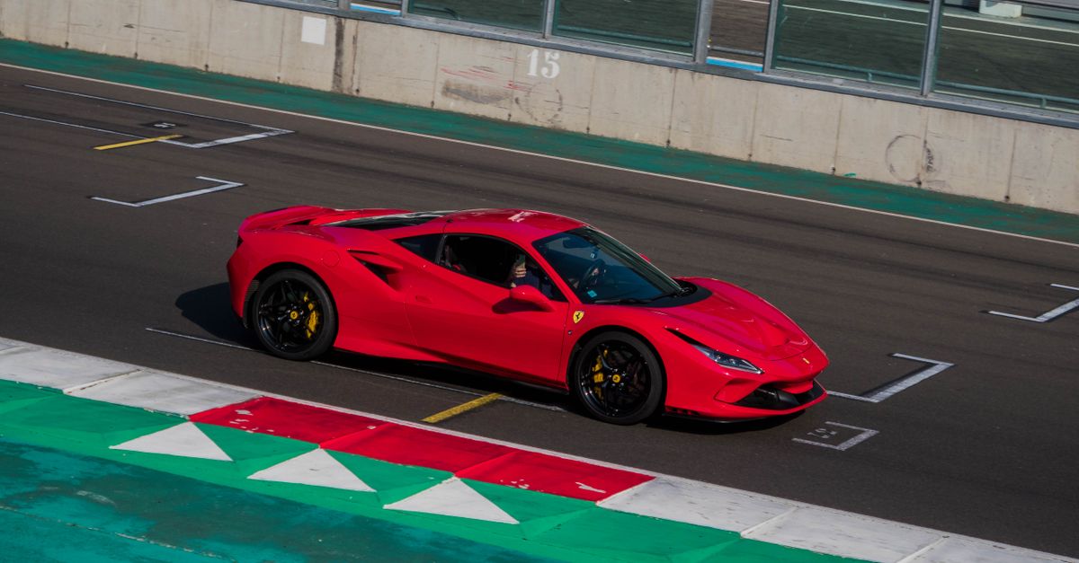 Una Ferrari rossa in pista, ripresa dall'alto mentre percorre il rettilineo lungo la corsia dei box