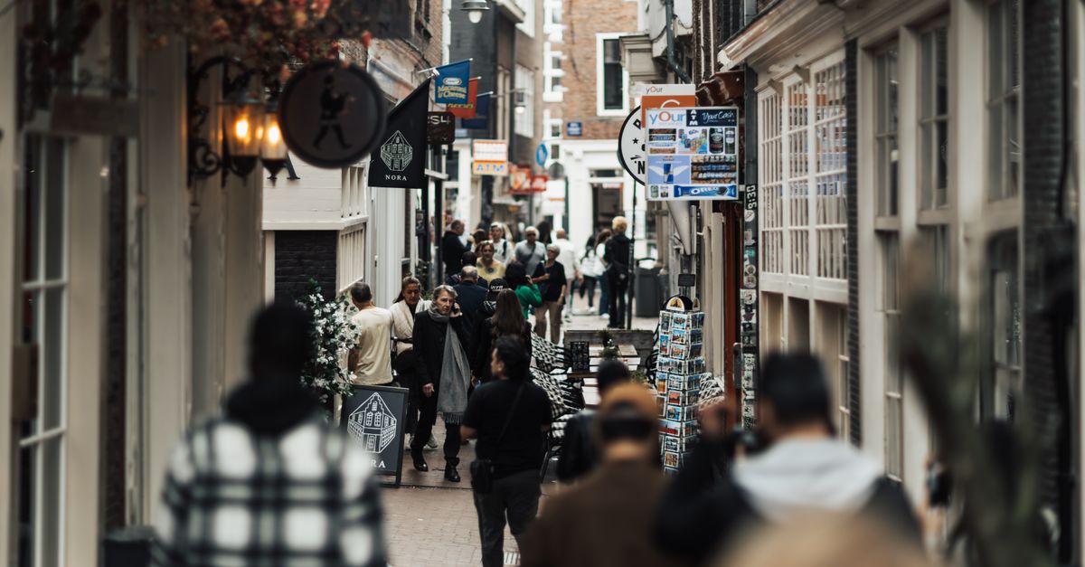 Una strada commerciale affollata in una città europea con persone che fanno acquisti, sabato 8 agosto 2026